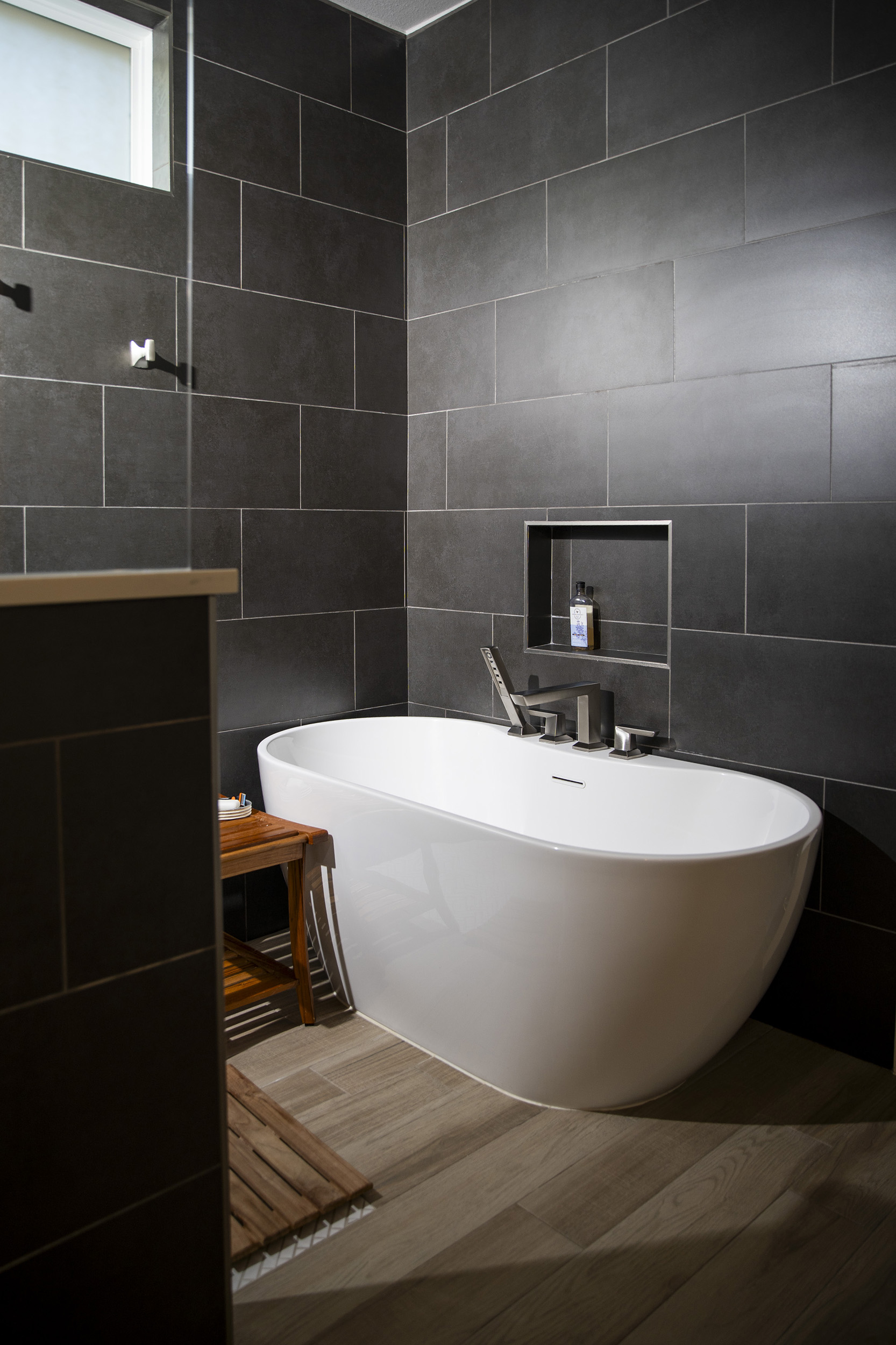 free standing tub wood look tile bathroom