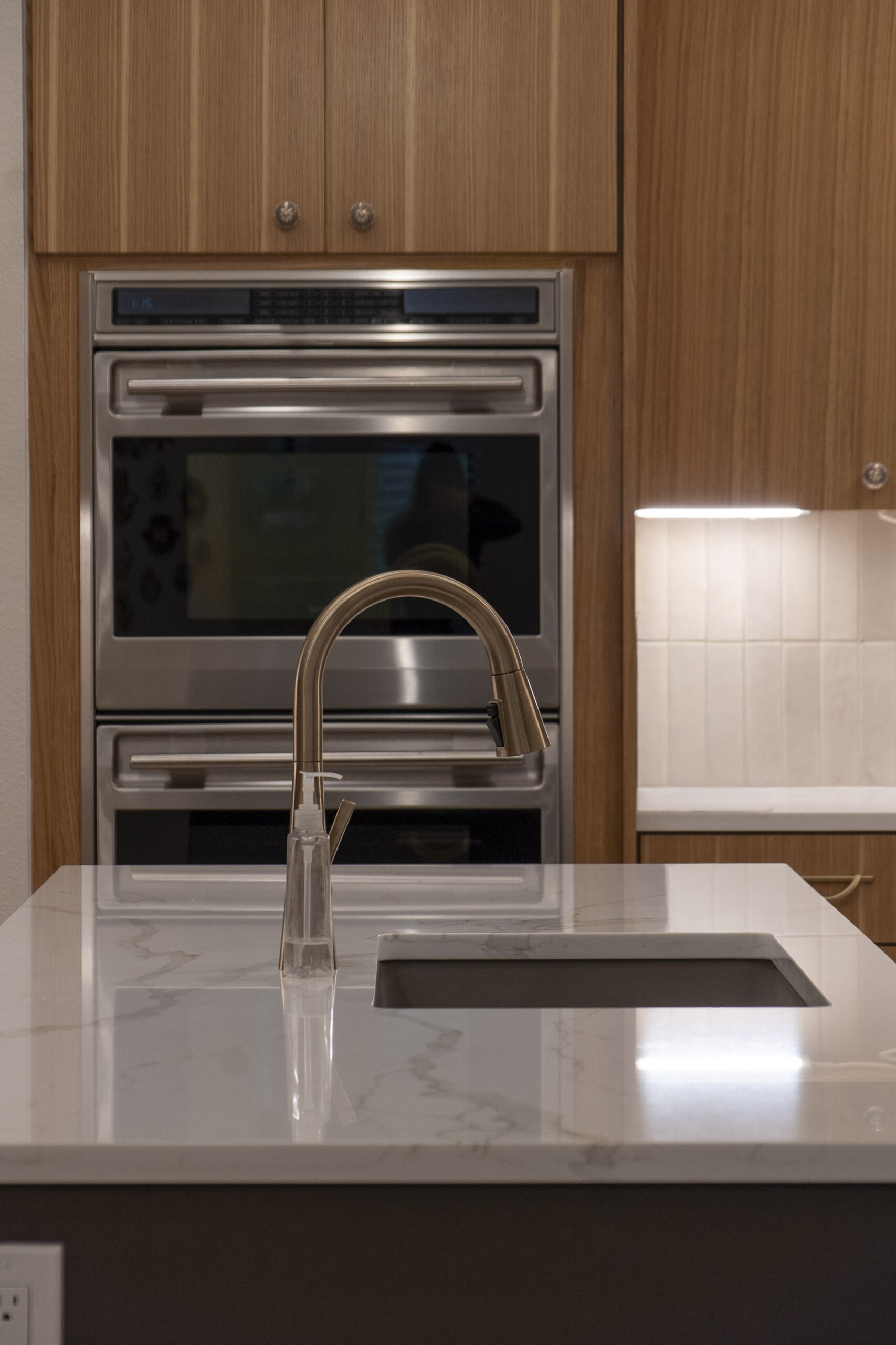 built in appliances, custom cabinets, kitchen island, stone countertops