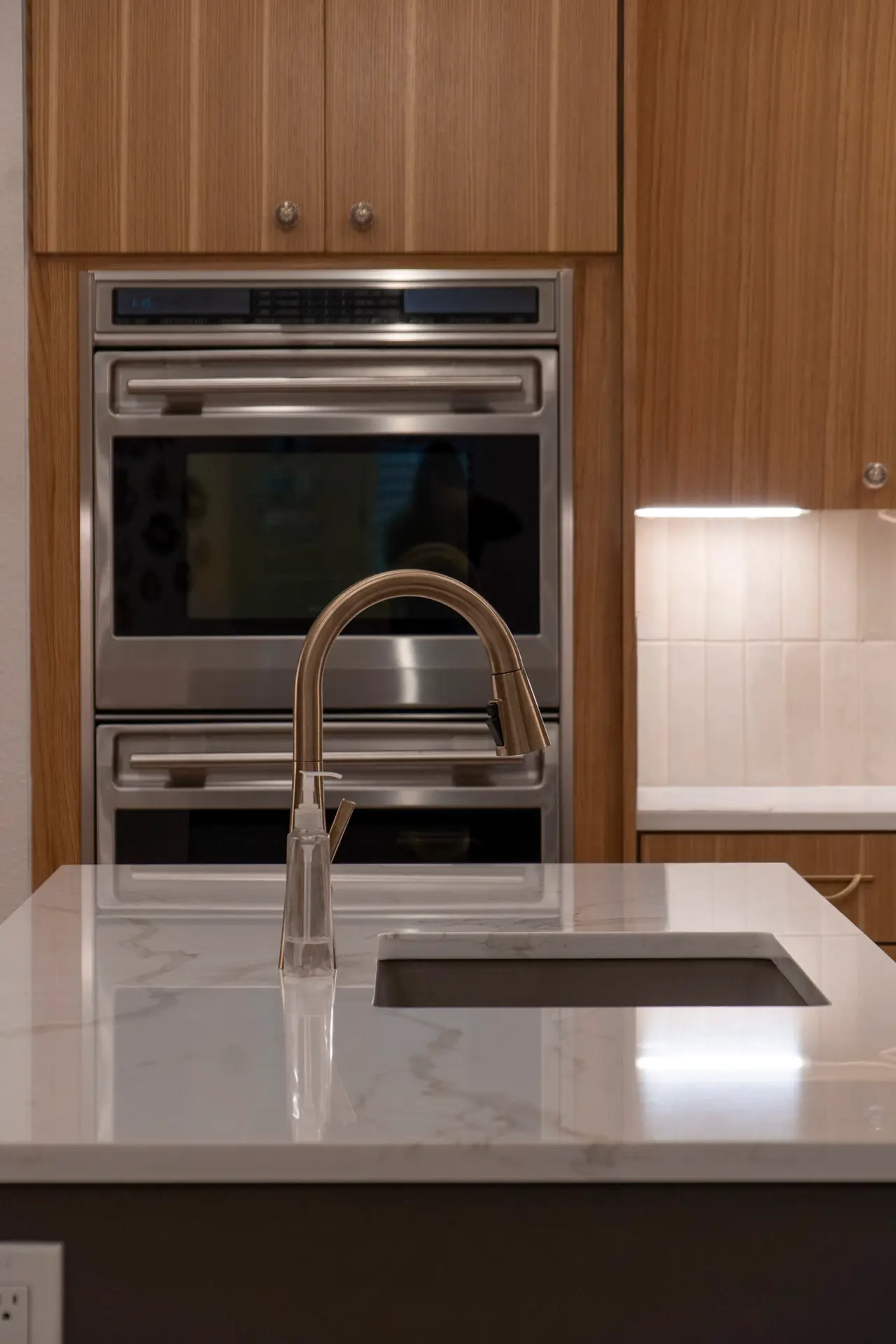 built in appliances, custom cabinets, kitchen island, stone countertops
